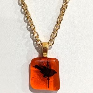 Handmade black bird on orange art glass pendant gold plated 18" chain.